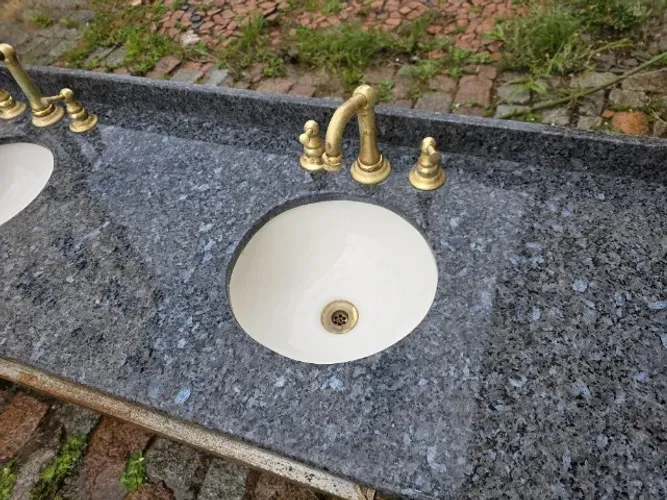 Tampo em Granito Azul Norueguês com cuba dupla e torneiras bronze