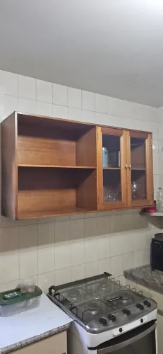 Armario em madeira cedro, com uma prateleira e porta de vidro de duas abas lado direito.