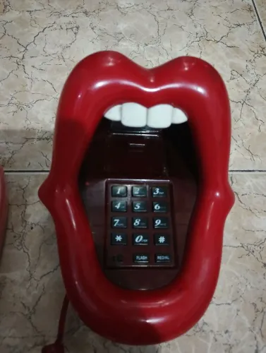 Telefone antigo em formato de boca mostrando a língua