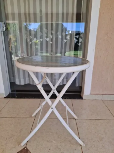 mesa de ferro na cor branca, redonda, tampo de vidro de 63 cm de diâmetro e 75 cm de altur