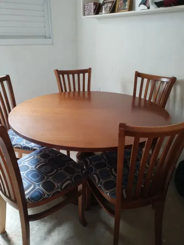 Uma mesa redonda com cico cadeira
