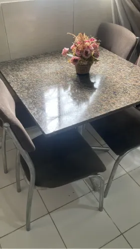 Mesa de mármore acompanhada de 4 cadeiras.