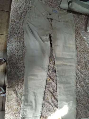 Calça jeans bege claro. Faltando um botão