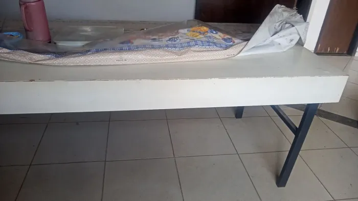 Mesa retangular de fórmica branca, com dois bancos, ideal para refeitórios.