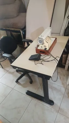 máquina de costura com a mesa e a cadeira funcionando 
