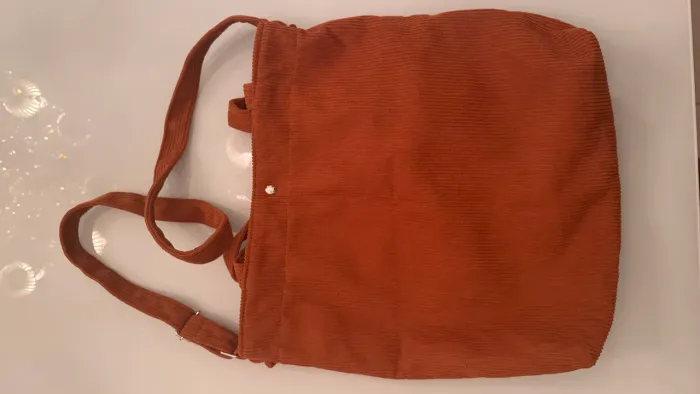 Bolsa em tecido canelado marrom.