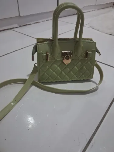 Bolsa verde claro com alça transversal ajustável, alça de ombro e ferragens douradas.