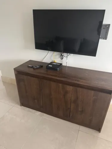 Um rack de TV usado com três portas em mdf/mdp amadeirado escuro