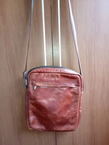 Bolsa lateral em couro legítimo.