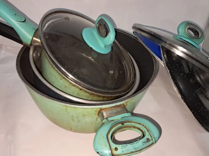3 panelas: 2 antiaderrente e 1 de aluminio com tampas.