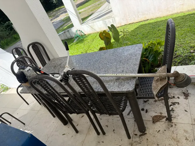 Mesa com tampo de granito, e pés de vime com 06 cadeiras.