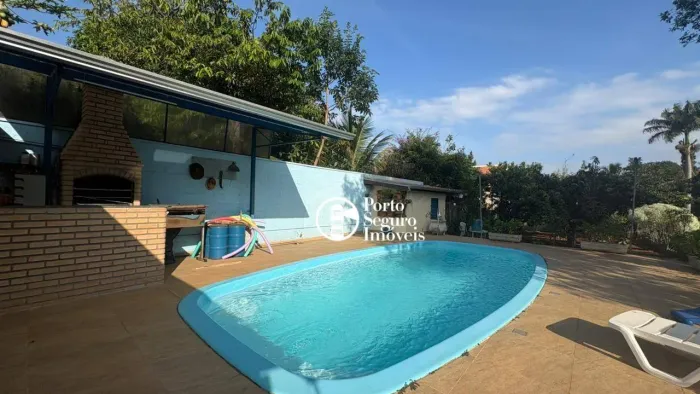 Chacára com piscina e área verde.