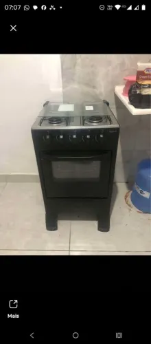 Fogão novo, uma geladeira e uma cama solteiro.