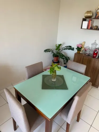 mesa de jantar com tampo de vidro e quatro cadeiras
