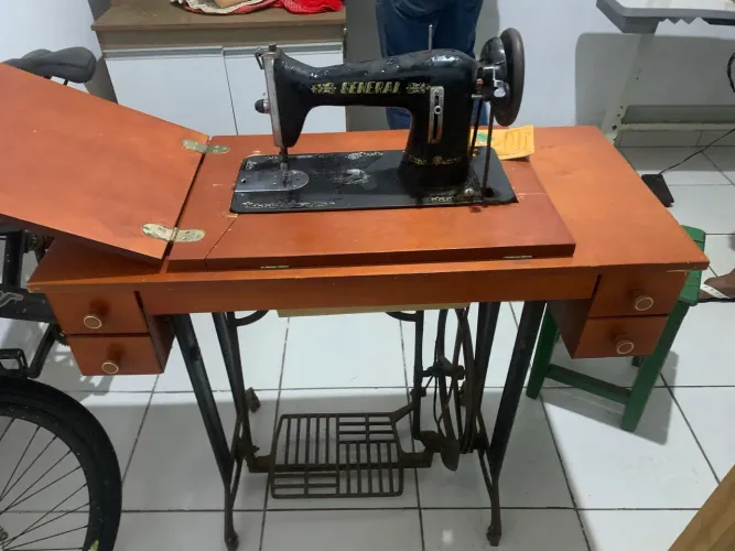 máquina de costura antiga da marca General, acoplada a um gabinete de madeira