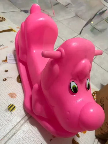 gangorra infantil de plástico rosa no formato de um cachorro