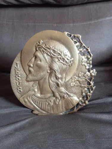 Placa arredondado com imagens de jesus apresenta detalhes em flores