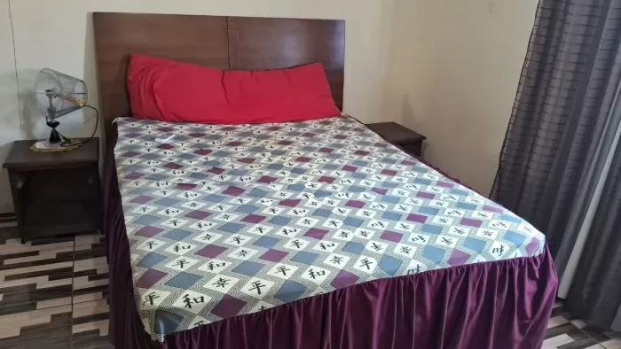 Cama king com cabeceira e mesas laterais