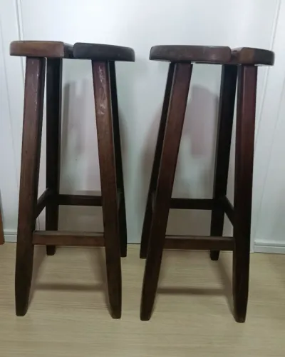 02 bancos de madeira de lei, mogno, década de 80, com 77cm de altura e 33cm de diâmetro