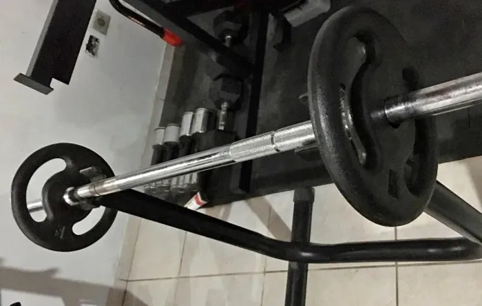Barra maciça com anilhas para musculação