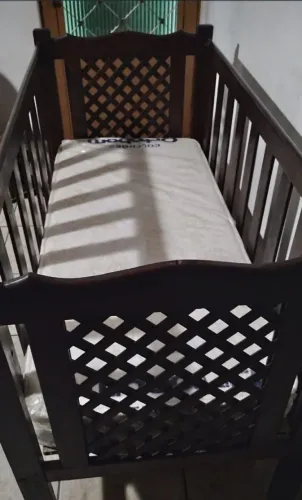 Berço de madeira maciça com colchão no plástico desde a compra.