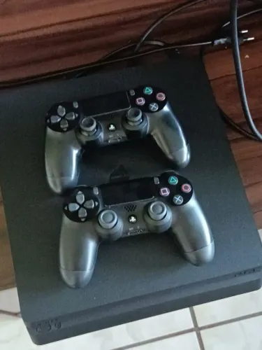 Ps 4 slim acompanha duas manete e jogos em mídia física 