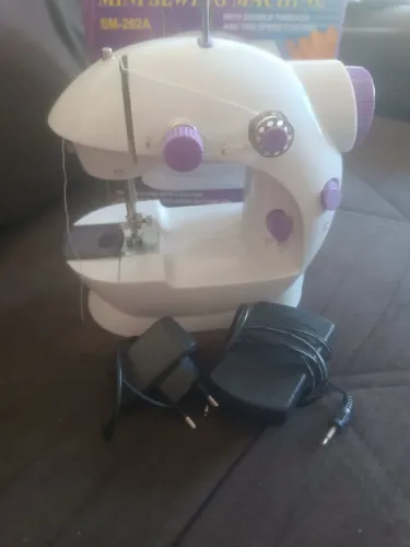 Mini máquina de costura,usada somente uma vez,com pedal e algumas linhas.linhas