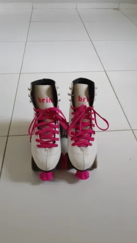 Patins quatro rodas, rosa e branco com botão.