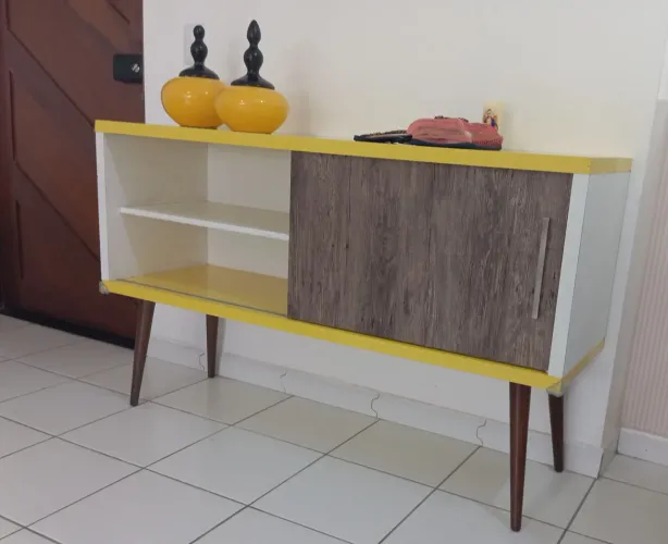 Buffet retrô de madeira com revestimento amarelo.