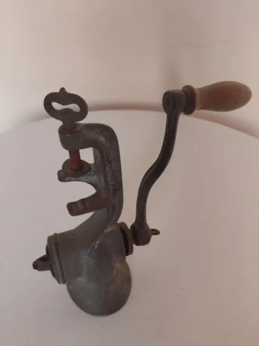 Moedor de carne manual vintage, de ferro fundido, frequentemente utilizado como peça de de