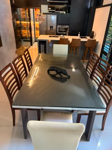 Mesa de madeira com tampo de vidro e oito cadeiras