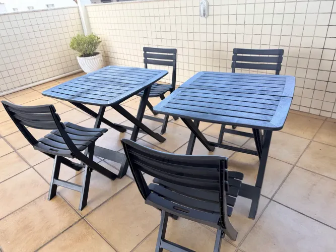 Kit de mesa e cadeiras dobrável de plástico preto.
