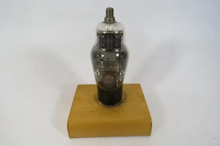 ANTIGA VÁLVULA de transmissão, colada em uma base de madeira. Serve para decoração de ambi