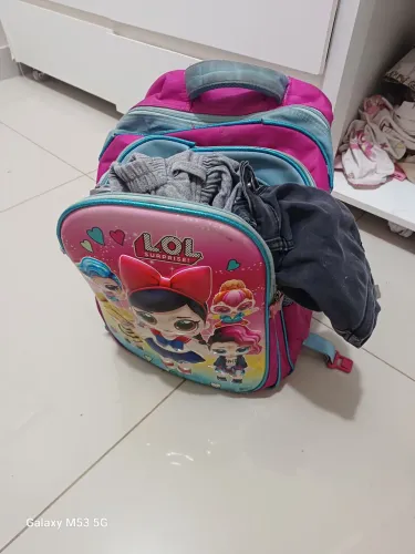 Roupa infantil e bolsa escolar usada