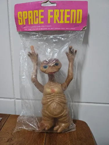 ET lacrado, original, olhos e dedo acendem.