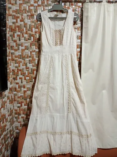 Elegante vestido longo branco com detalhes de bordados dourados e renda.