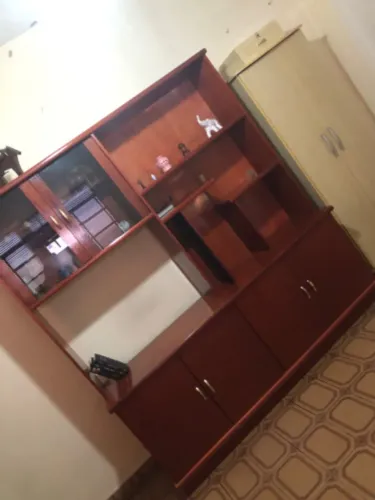 Estante de sala antiga, em madeira, com prateleiras, nichos e armários com portas.