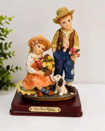 ESTATUETA EM RESINA DECORATIVA - CASAL DE CRIANÇAS COM CACHORRINHO