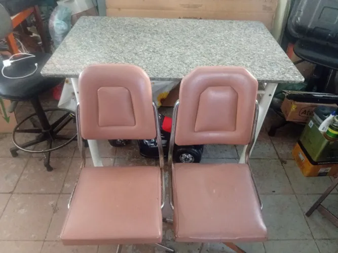 Mesa com tampo de granito cinza com três cadeiras