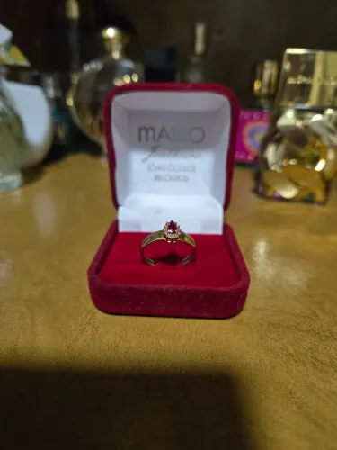 Anel com pedra de rubi e alguns diamantes ao redor 