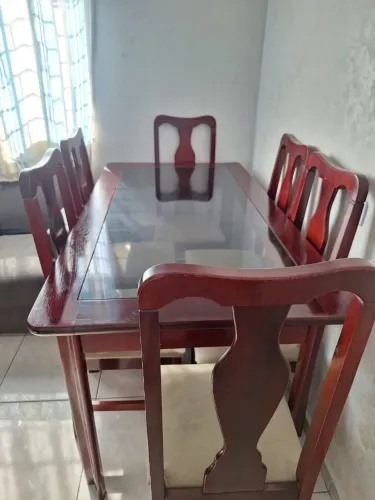 Mesa de madeira com tampo de vidro.