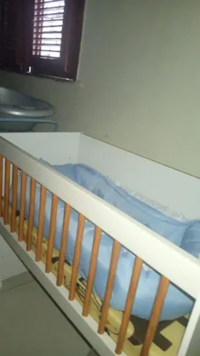 Estou vendo um mini berço, já vem com o colchão, e a companha com um ninho azul 