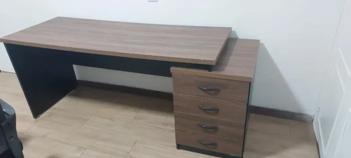 Mesa de escritório espaçosa, com acabamento amadeirado e gaveteiro com 4 gavetas