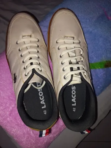 Tênis Lacoste bege de estilo casual.