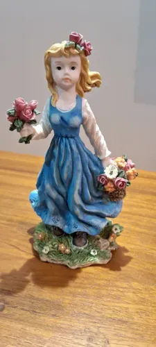 Linda escultura de menina com flores