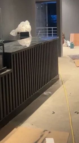 Balcão de atendimento preto ripado com mármore verde Ubatuba
