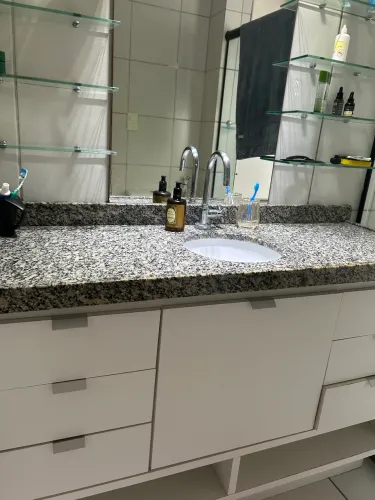 Bancada de granito com torneira e móvel. 
