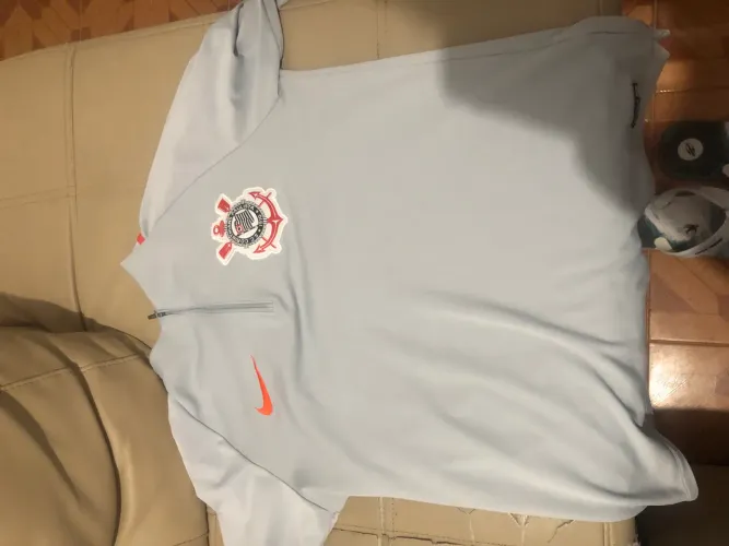 camisa de treino Nike Corinthians Academy cinza com detalhes em laranja.
