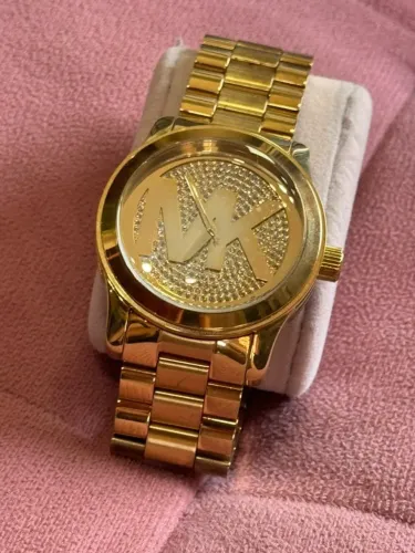 Relógio Michael Kors em tom dourado com logo MK no mostrador