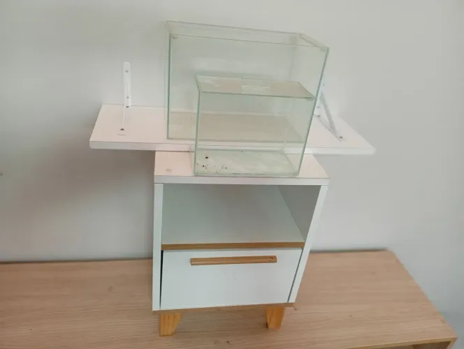 Gabinete pequeno em MDF, suporte em madeira para  livros e dois aquários pequenos.